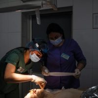 a surgeon working on an injured lady