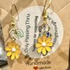 sunflowers1 Gold-tone dangle earrings with yellow daisy charms on a kraft display card in view of a shopping tag