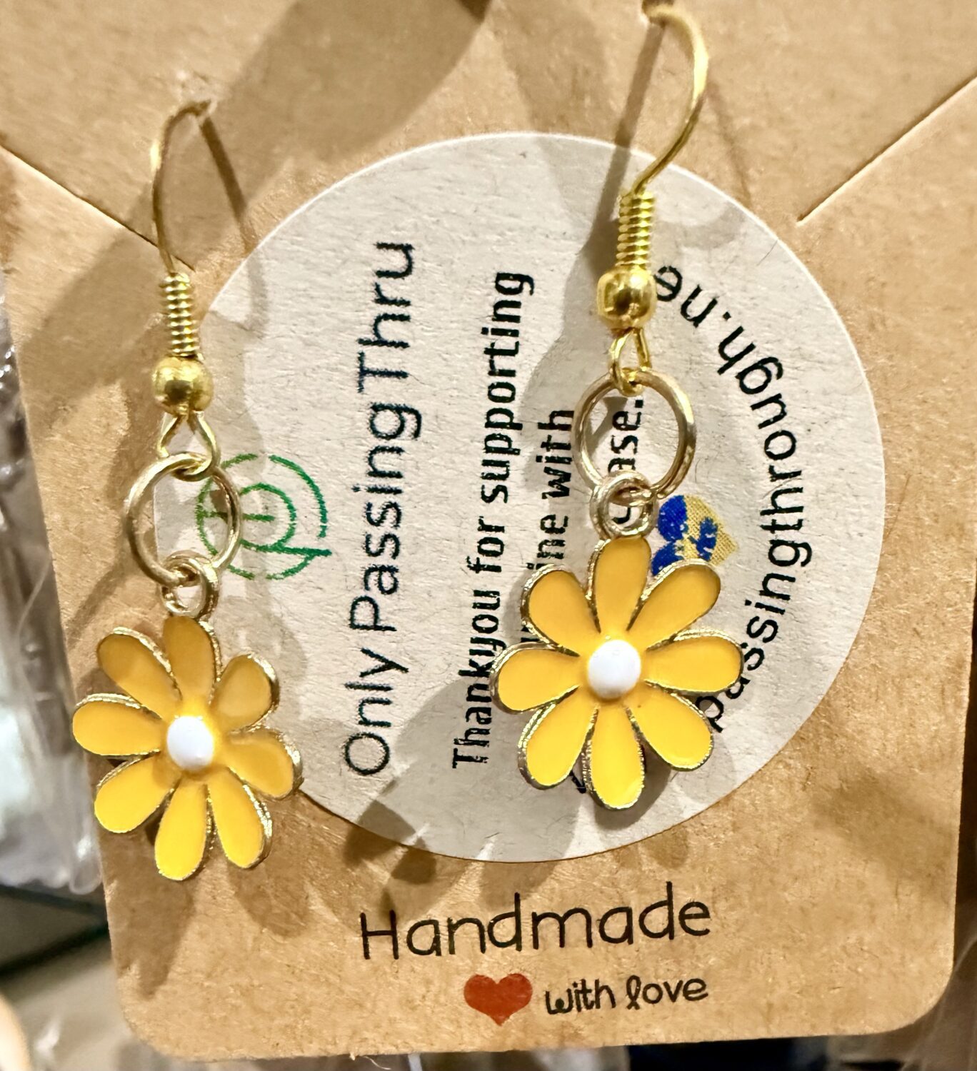 sunflowers1 Gold-tone dangle earrings with yellow daisy charms on a kraft display card in view of a shopping tag