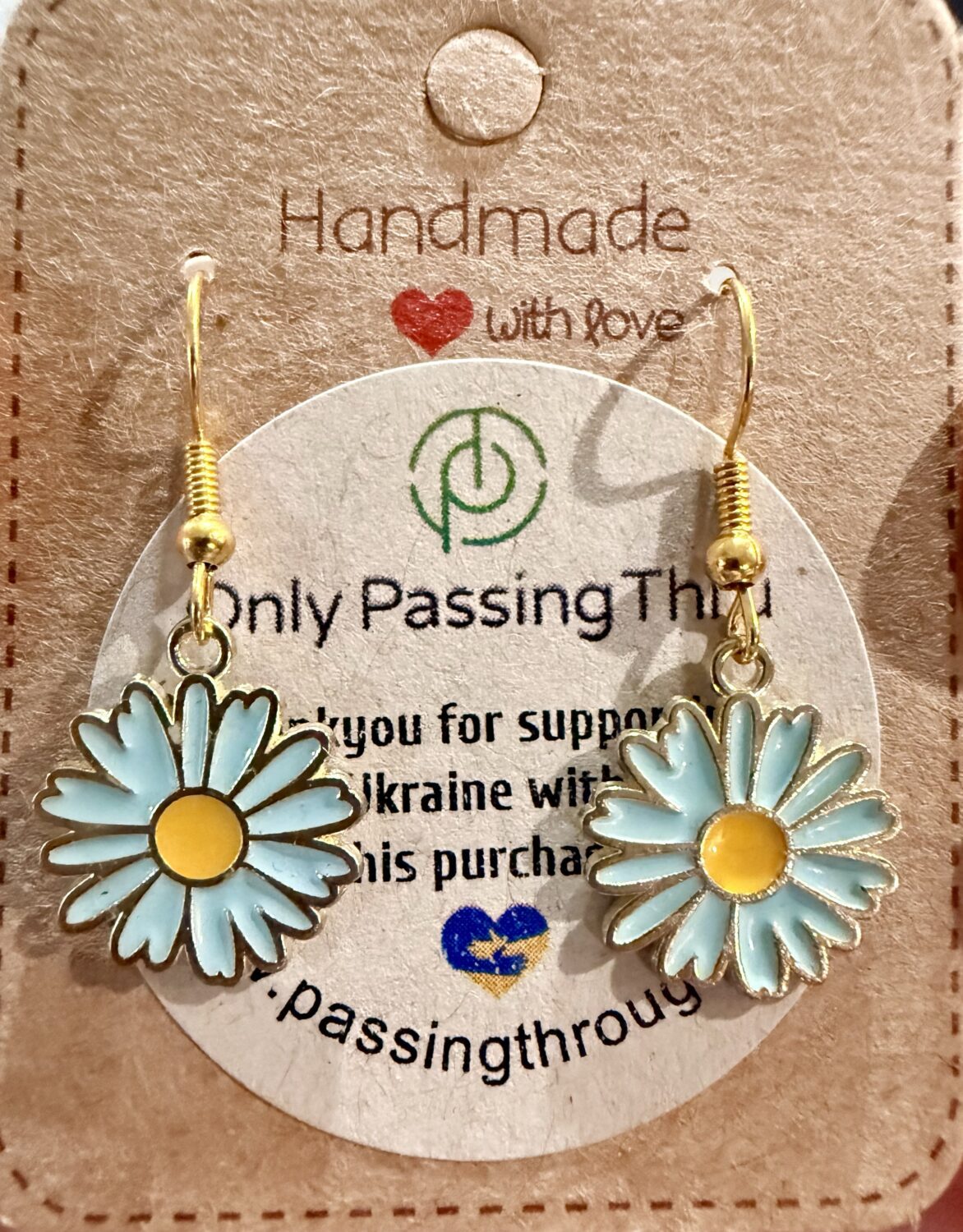 blue daisies1 Gold-tone hook earrings with light blue enamel daisies and yellow centers hanging from a display card that says Handmade with love and Only Passing Through