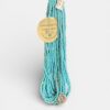 Turquoise multi-strand beaded necklace with a gold-tone sunflower pendant and a round tag reading 'Only Passing Thru'.