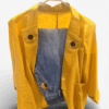 Bright yellow blazer on a hanger with denim inner lining and sunflower patches on the lapels.