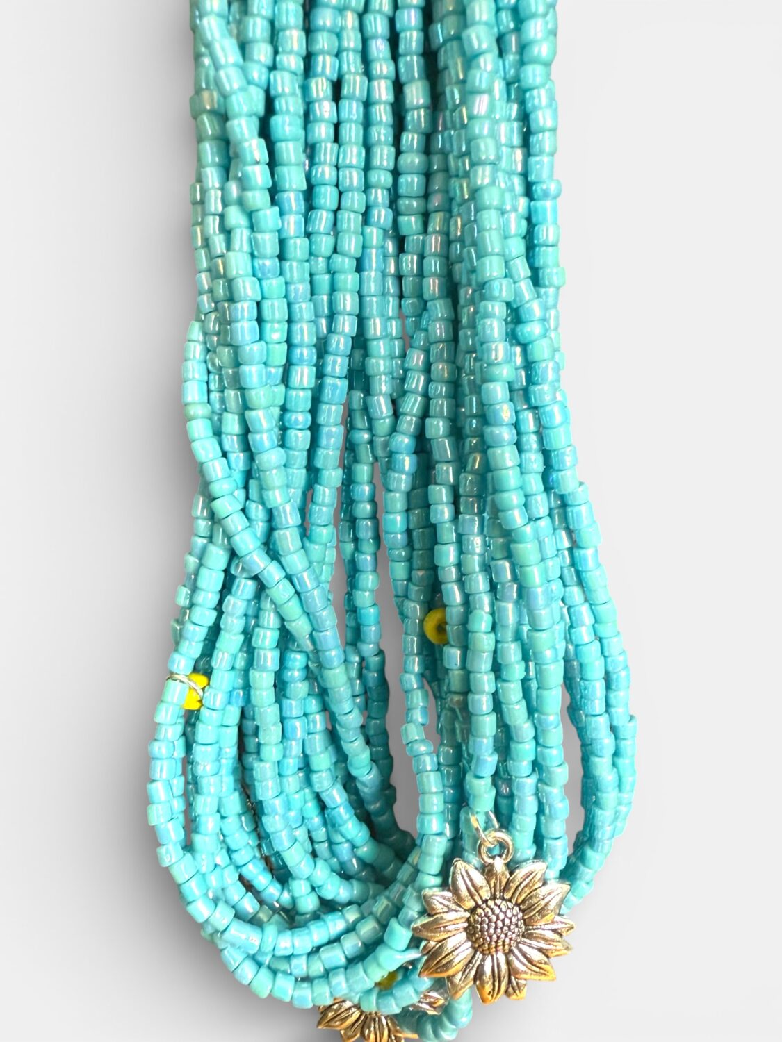Turquoise beaded multi-strand necklace with a gold sunflower pendant
