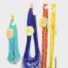 Colorful beaded necklaces in turquoise, royal blue, red, and yellow hanging against a light background with price tags.