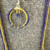 Beaded hoop earring in purple and yellow with a small bead-figure charm hanging from the top, surrounded by matching bead strands.