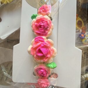 Bracelet with pink gradient rose beads and green leaves on white carding surface.