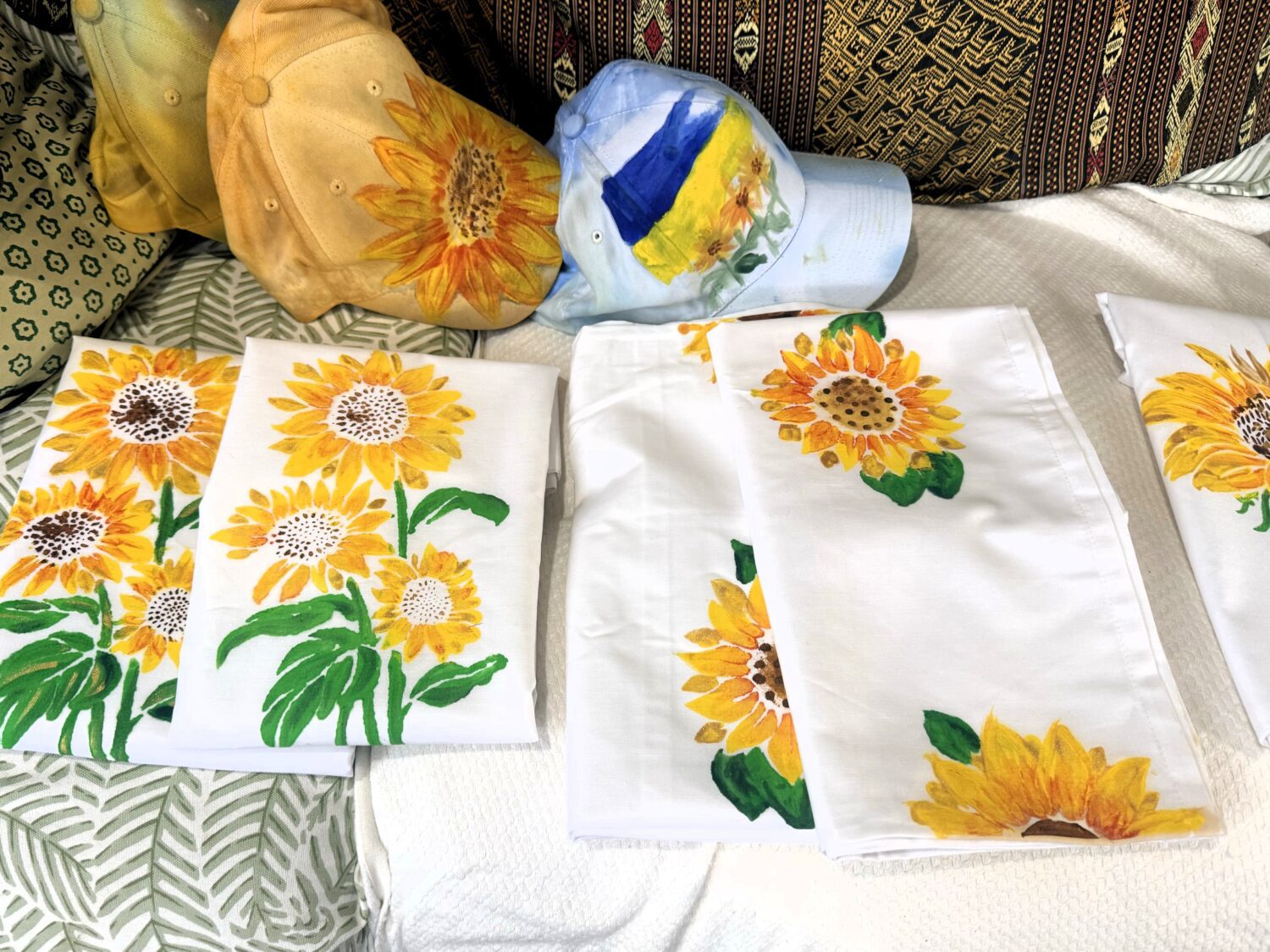 White fabric napkins with bright yellow sunflower prints laid on a couch.