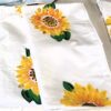 White fabric napkins with bright sunflower prints scattered around.