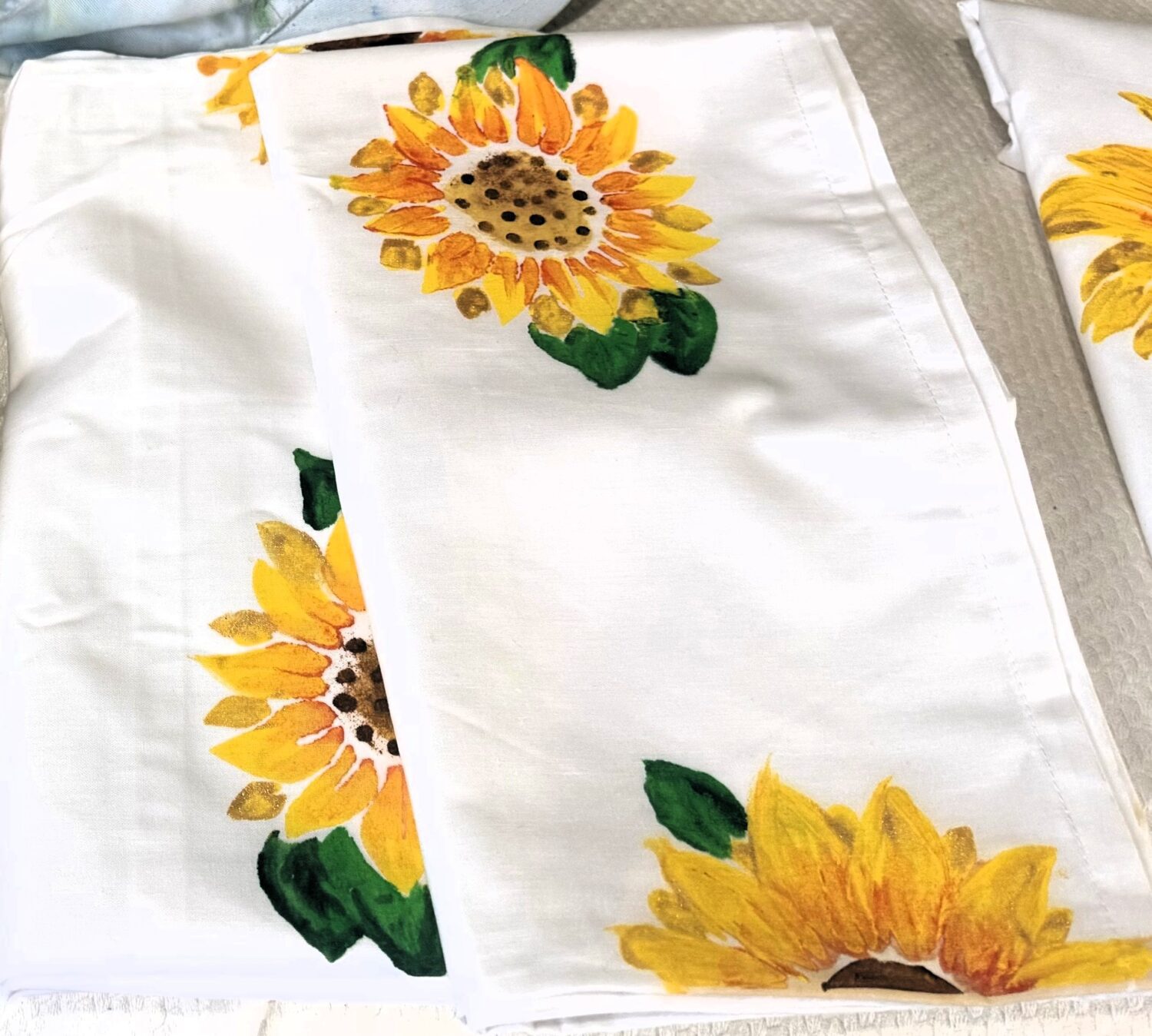 White fabric napkins with bright sunflower prints scattered around.