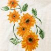 Orange sunflower prints on a light fabric, with green leaves and stems interwoven among the blossoms.
