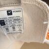 Label inside a white garment showing 'WOMAN' and size chart (US 8, UK 6, JP 25, BR 37) with care icons and 'do not machine wash' note.