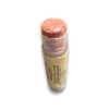 Peach-pink lipstick portion exposed from a cork-wrapped tube against a white background
