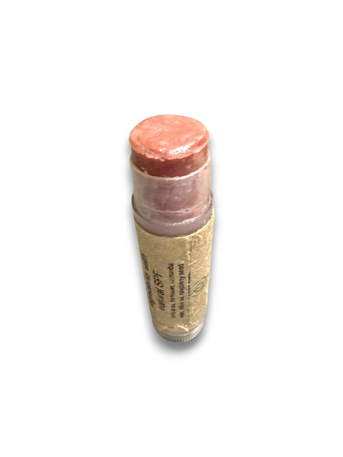 Peach-pink lipstick portion exposed from a cork-wrapped tube against a white background