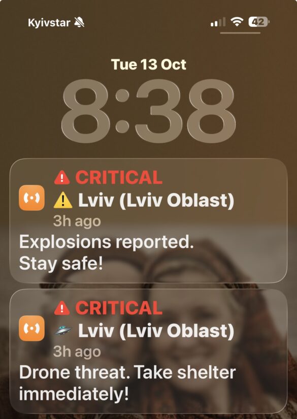 Screenshot Phone lock screen showing two critical emergency alerts: Explosions reported in Lviv and a drone threat, with time 8:38, Kyivstar carrier.