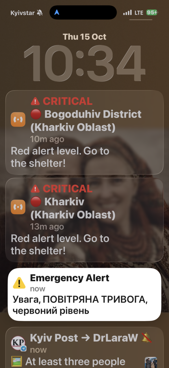 IMG_8595 Lock screen showing two CRITICAL alerts about Red alert level in Kharkiv Oblast, urging people to go to shelter; time 10:34 visible.