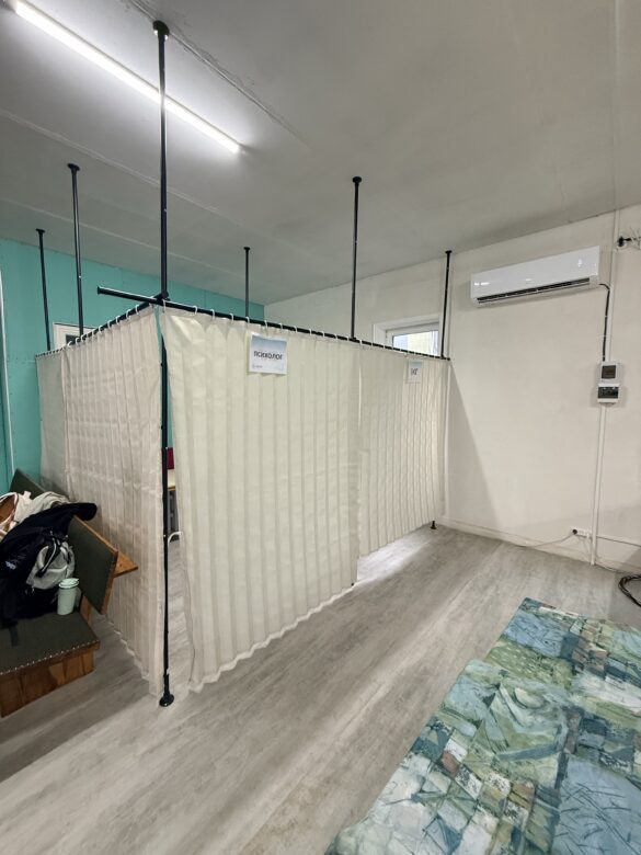 IMG_8647 Privacy-screened area in a clinic with signs reading 'psychologist' (in Cyrillic); partition walls create individual booths.